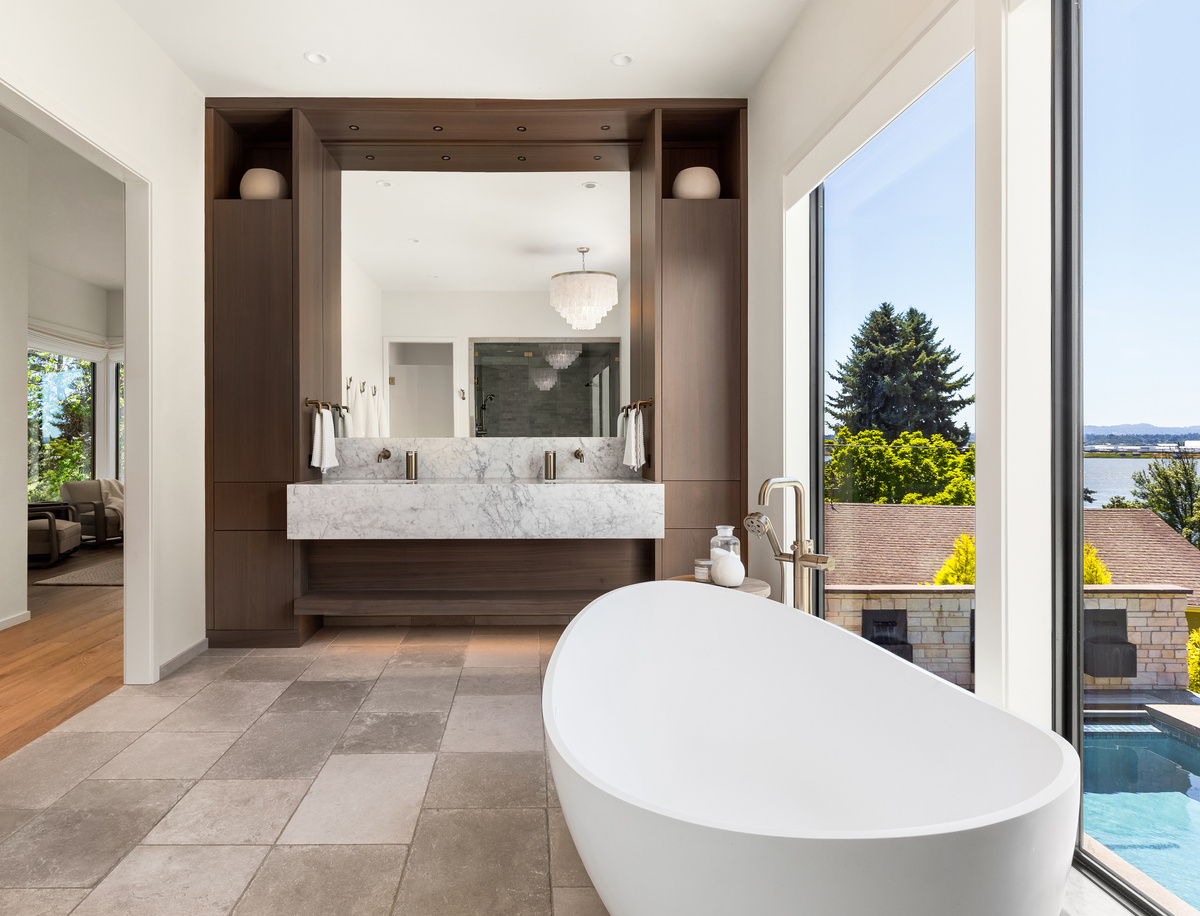 Primary ensuite bathroom interior in luxury home with large soaking tub and double vanity with large mirror